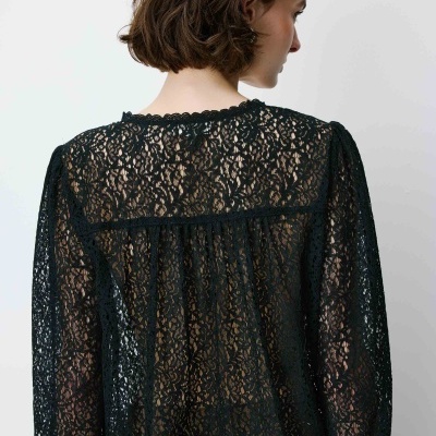 Blusa preta de renda com padrão floral vista de costas