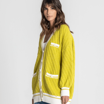 Cardigan feminino amarelo com detalhes brancos usado com jeans