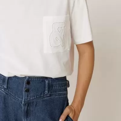 T-shirt branca com bolso bordado e calças de ganga azuis