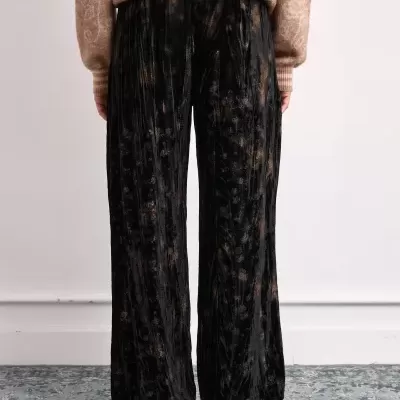 Calças largas pretas com padrão floral e camisola bege com padrão texturado