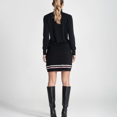 Mulher vista de costas com camisola e saia preta de malha, botas pretas até ao joelho.