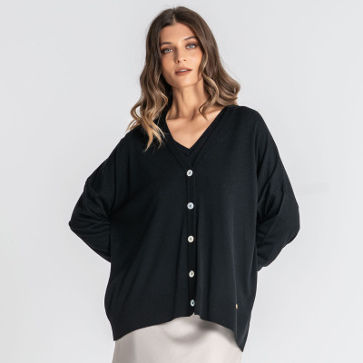 Cardigã feminino preto com botões brancos e saia bege clara