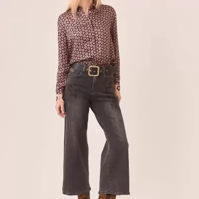 Conjunto feminino com blusa floral rosa e preta, calças largas pretas, cinto preto e botas castanhas