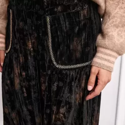 Calças de veludo pretas com bolso decorativo e camisola castanha de malha