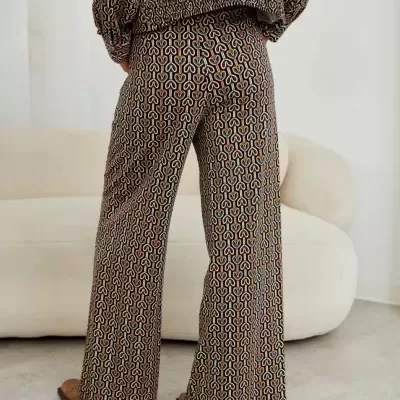 Calças compridas com padrão geométrico colorido em ambiente interior