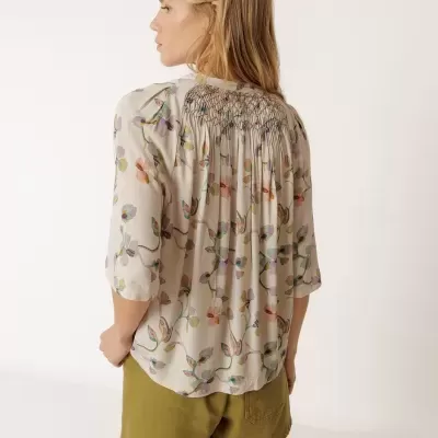 Blusa bege com flores coloridas e calções cor de oliva