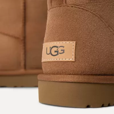Detalhe de bota UGG castanha de camurça com etiqueta no calcanhar