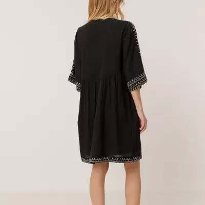 Vestido preto com bordados brancos visto de costas