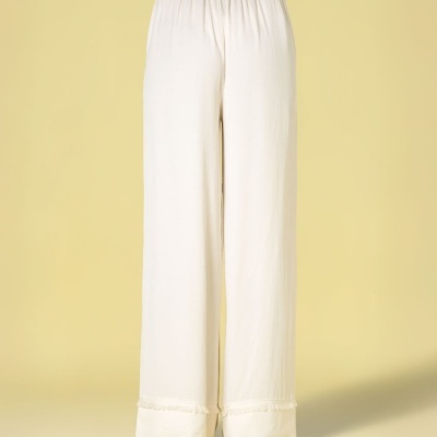 Calças largas brancas com cinto castanho vistas de costas