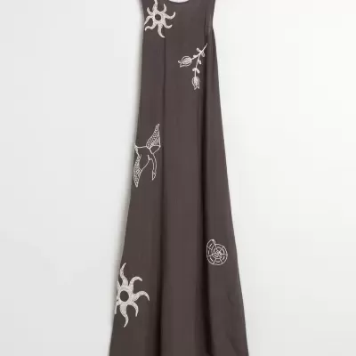Vestido castanho escuro de linho com bordados brancos de sol, folhas, pássaro e concha