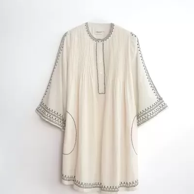Túnica branca com bordados pretos e botões brancos.