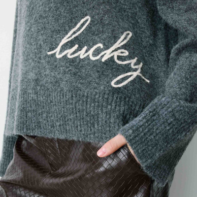 Camisola de lã cinzenta com texto lucky e calças de pele sintética castanhas com padrão xadrez