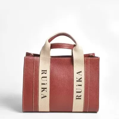 Mala de mão castanha em pele com alças de tecido bege com texto RUIKA