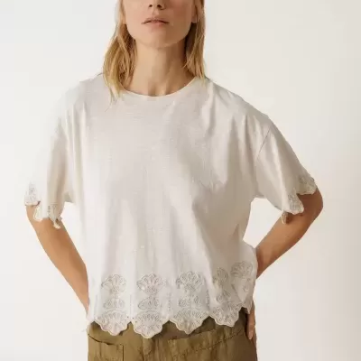 Camisola branca com bordados florais e calças castanhas largas