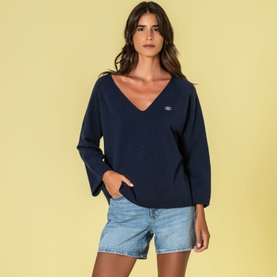 Mulher com camisola azul escura de malha e calções de ganga claros