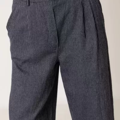 Calças risca de giz azul escuro com riscas brancas e blusa preta bordada