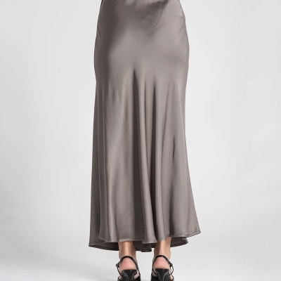 Saia comprida cinzenta e sapatos pretos de salto alto vista de costas