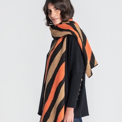 Mulher com camisola preta e cachecol às riscas laranja, preto e castanho