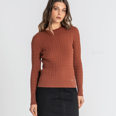 Mulher com camisola castanha de malha trançada e saia preta