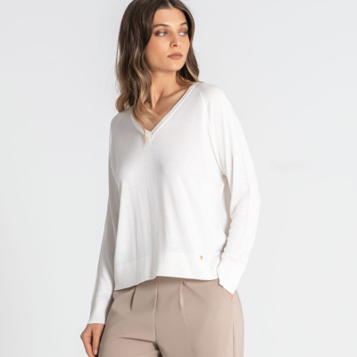 Camisola branca feminina com decote em bico e calças bege