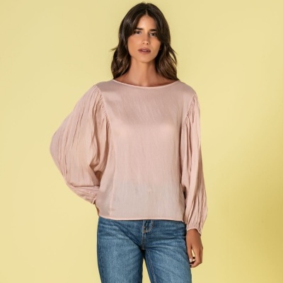 Blusa rosa claro de mangas bufantes com jeans azul.