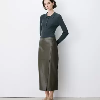 Mulher com camisola cinza escura e saia verde musgo em fundo branco