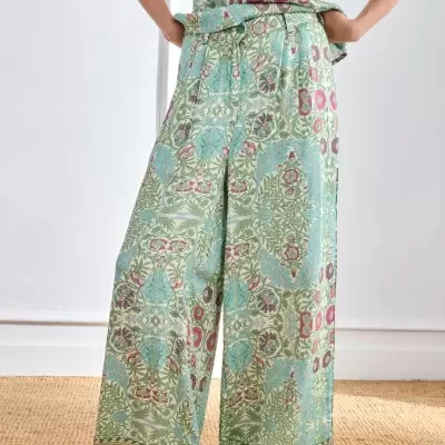 Calças largas com padrão floral verdes e azuis