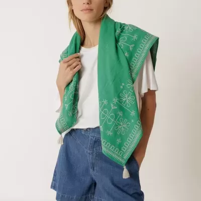 Lenço verde bordado com pompons usados por mulher com roupa casual