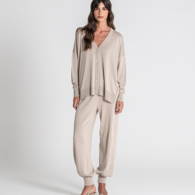 Conjunto de roupa bege feminino com cardigan e calças de malha.