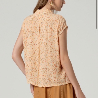 Blusa feminina com padrão abstrato bege e laranja e saia mostarda