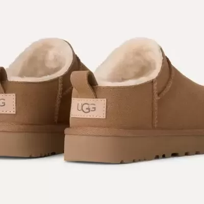 Chinelos UGG castanhos com forro branco e logo na parte traseira