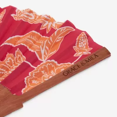 Leque com padrão floral vermelho e laranja em madeira com texto GRACE & MILA