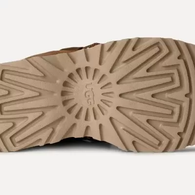 Sola castanha clara de calçado com padrão geométrico e texto UGG