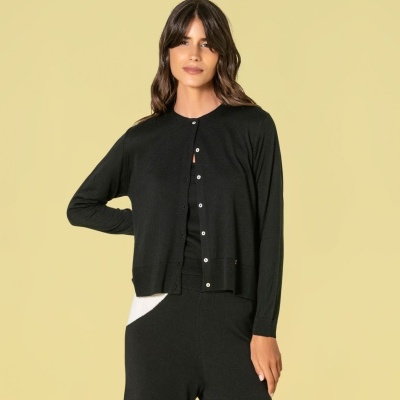 Mulher vestindo casaco cardigan preto e calças pretas com detalhe branco