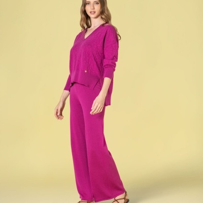 Mulher com conjunto de malha rosa vibrant e sandálias castanhas