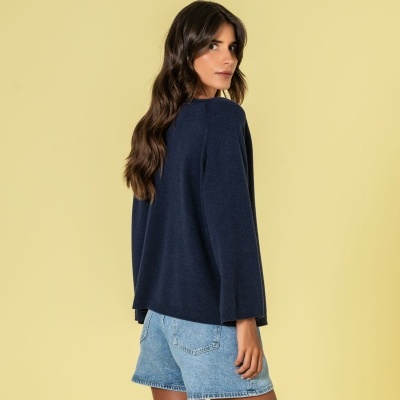 Mulher de costas com camisola azul escura e calções de ganga azul clara