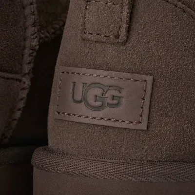 Pormenor de bota castanha em camurça com etiqueta UGG em relevo