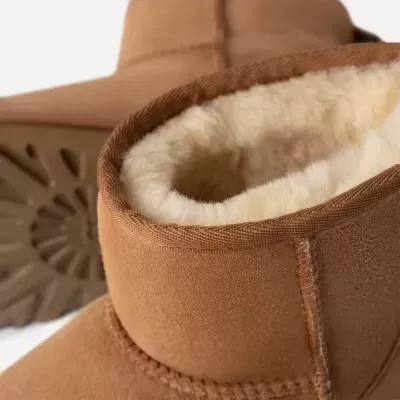 Botas castanhas de camurça com interior forrado a pelo branco e sola antiderrapante.