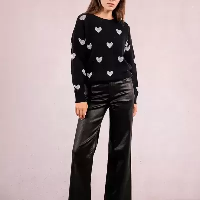 Mulher com camisola preta com corações brancos e calças largas pretas