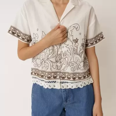 Camisa branca bordada com calções de ganga azuis