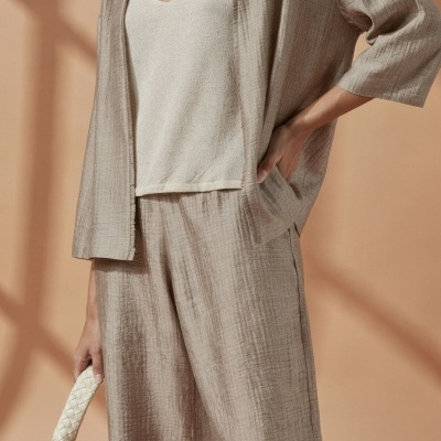 Conjunto feminino bege com tecido texturizado e mala trançada