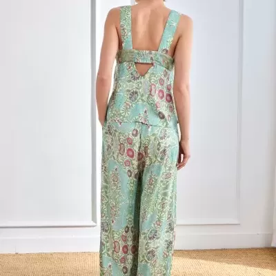 Conjunto de top e calças com padrão floral verde, azul e rosa visto de costas