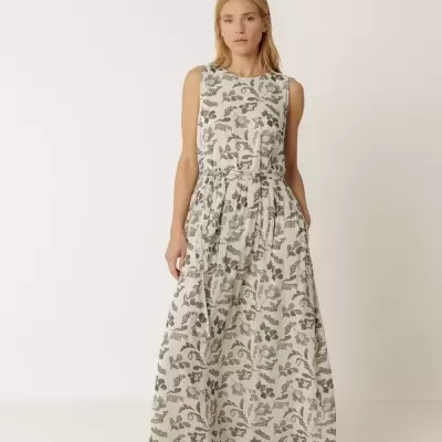 Vestido longo floral com sandálias castanhas.