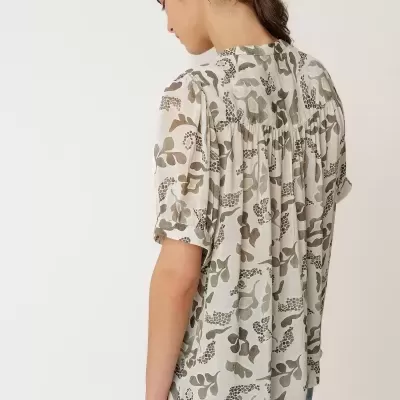 Blusa feminina com padrão floral em tons verdes e castanhos vista de costas