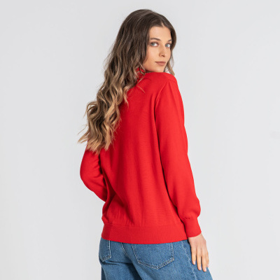 Mulher de costas com camisola vermelha e calças de ganga azuis