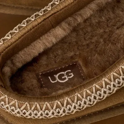 Interior castanho felpudo de calçado com costura branca entrelaçada e etiqueta UGG
