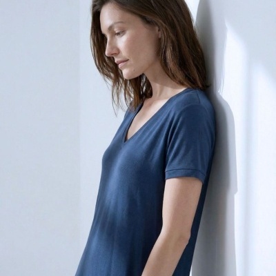 Vestido azul escuro de manga curta com decote em V num ambiente branco minimalista