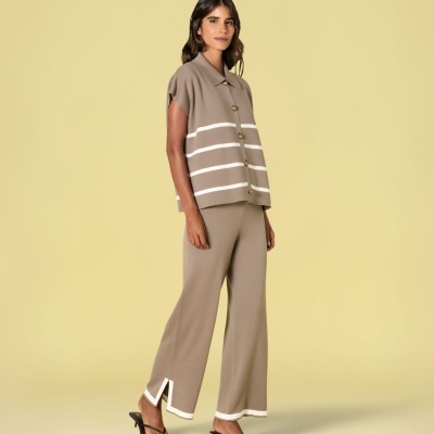 Mulher vestindo conjunto bege de malha com riscas brancas e sandálias pretas de salto baixo