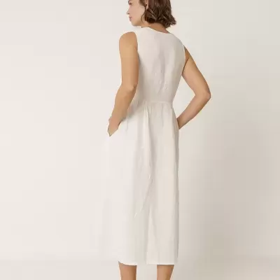 Mulher de costas com vestido midi branco e sapatos rasos brancos