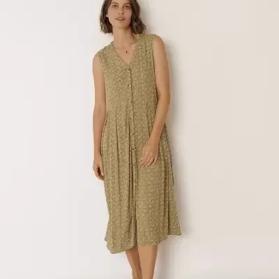 Vestido midi verde com padrão de triângulos e sandálias castanhas